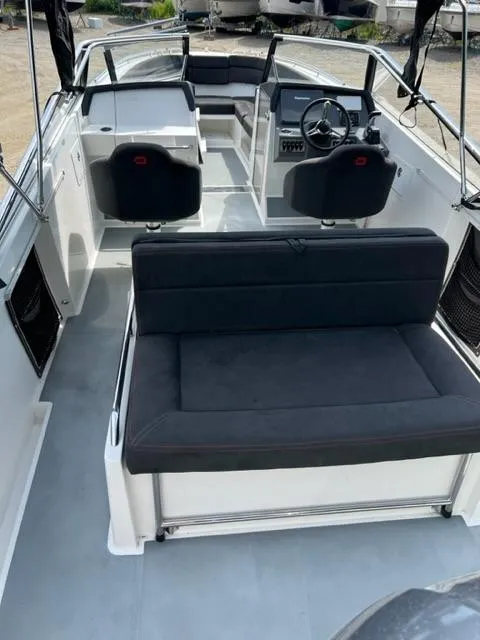 Slide: The Image of 2016 Draco 27 RS boat interior with black seating and steering console. - 28