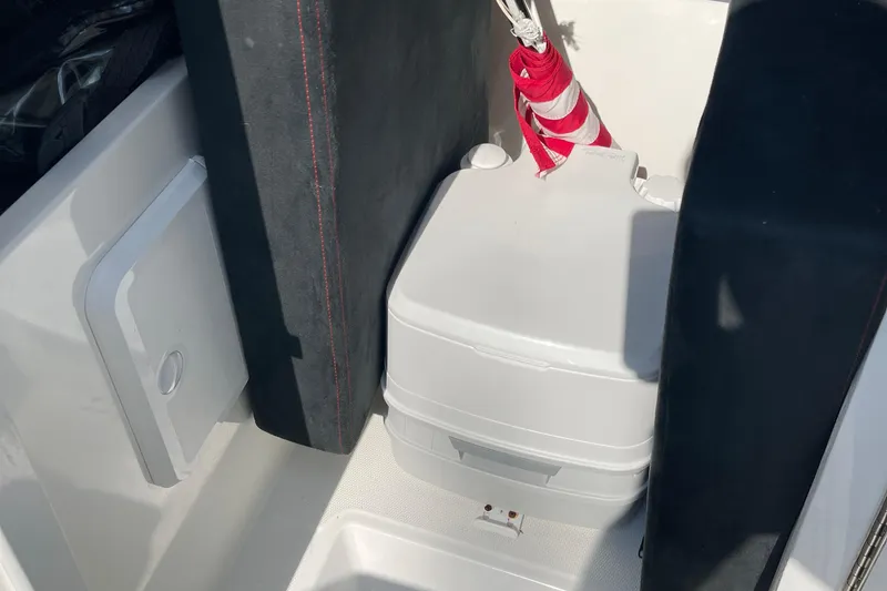 Slide: The Image of 2016 Draco 27 RS boat interior with portable toilet and storage compartment. - 30