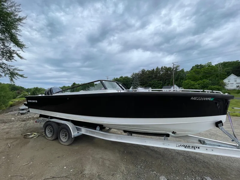 Slide: The Image of 2016 Draco 27 RS boat on Load Rite trailer, black and white hull, parked outdoors. - 7