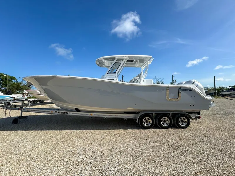 Slide: The Image of 2025 Sea Fox 328 Commander boat on trailer under clear blue sky. - 1
