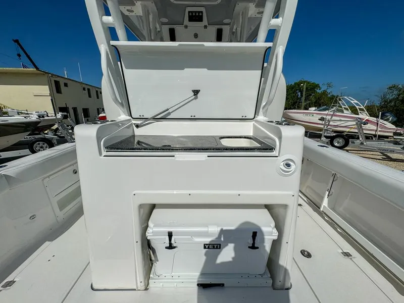 Slide: The Image of 2025 Sea Fox 328 Commander boat with open storage compartment and Yeti cooler on deck. - 12