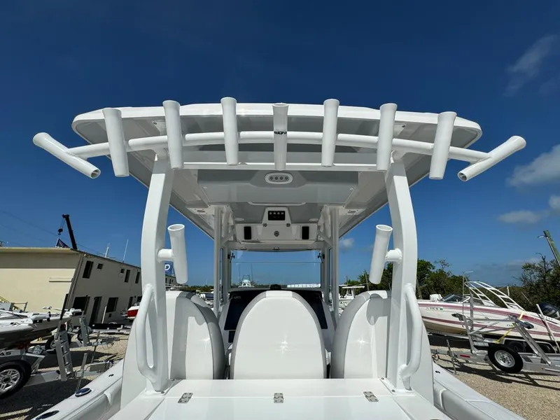 Slide: The Image of 2025 Sea Fox 328 Commander boat with rod holders, viewed from the rear under a clear blue sky. - 13