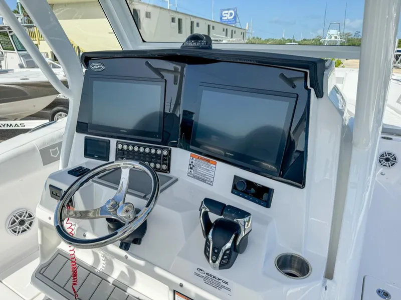 Slide: The Image of 2025 Sea Fox 328 Commander boat dashboard with dual screens and steering wheel. - 15
