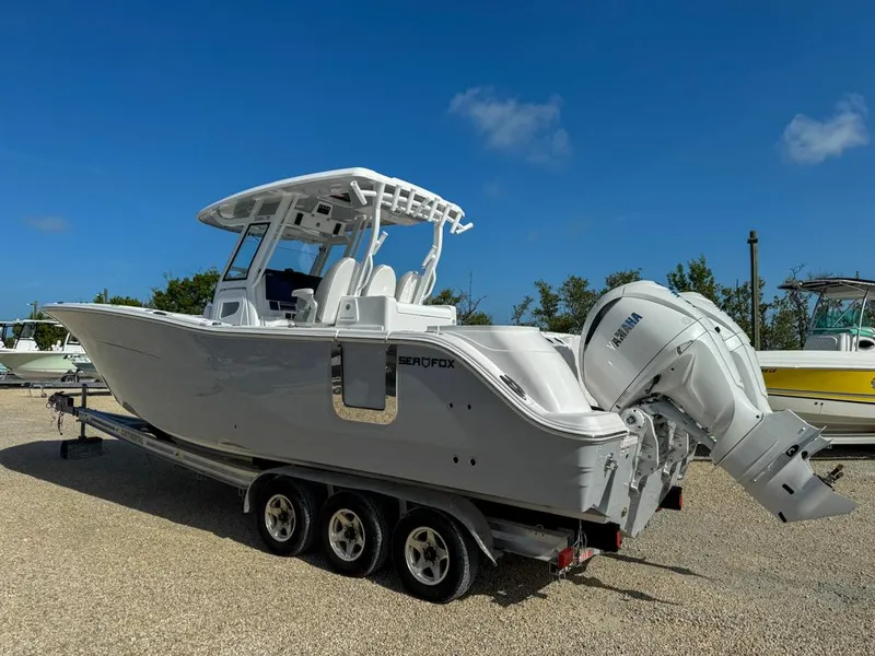 Slide: The Image of 2025 Sea Fox 328 Commander boat on trailer under clear blue sky. - 2