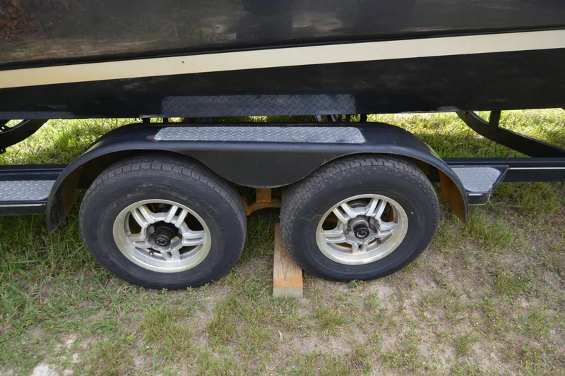 Slide: The Image of Trailer wheels of a 2012 Four Winns F244 boat on grass. - 24