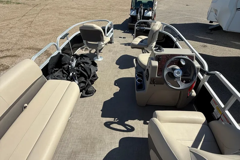 Slide: The Image of 2022 Sun Tracker Bass Buggy 16 XL Select pontoon boat interior with beige seating and steering console. - 8