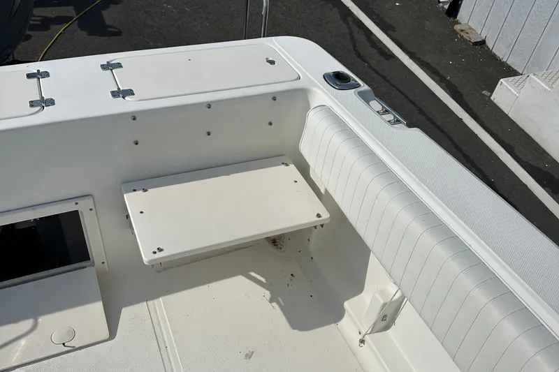 Slide: The Image of 2004 Hydra-Sports 230 WA boat interior with white seating and storage compartments. - 7