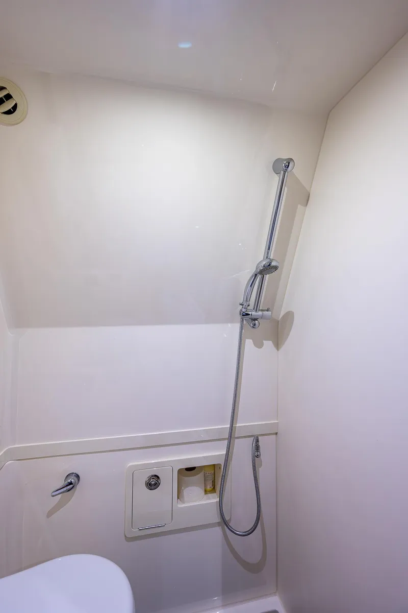 Slide: The Image of 2021 Gulf Crosser 52 yacht bathroom with showerhead and white interior. - 45