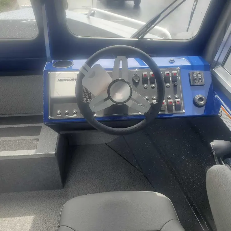 Slide: The Image of 2024 Spartan 215 Athens boat dashboard with steering wheel and control panel. - 15