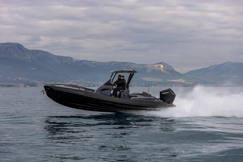 Slide: The Image of 2026 SuperRib Open 27 speeding on water with mountainous backdrop. - 11