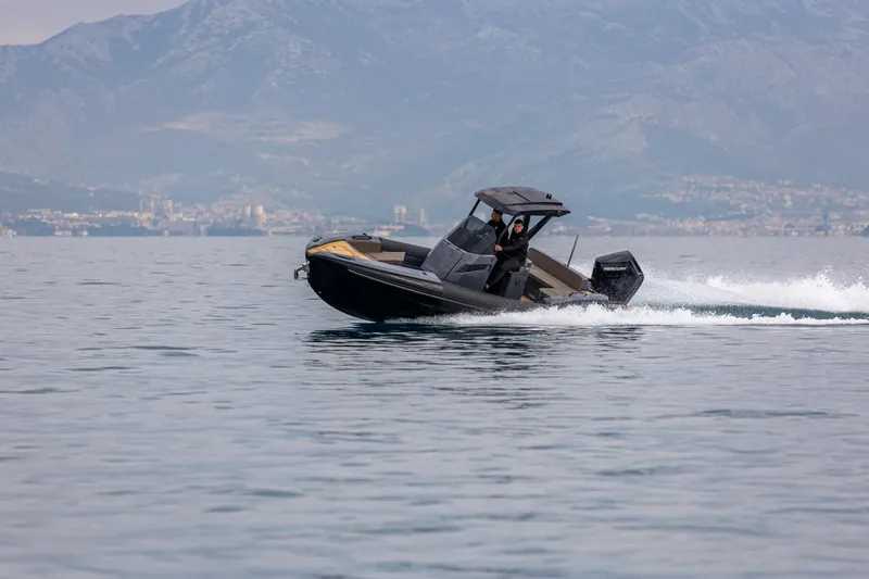 Slide: The Image of 2026 SuperRib Open 27 speeding on water with mountainous backdrop. - 14
