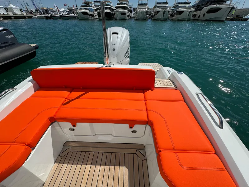 Slide: The Image of SuperRib Open 27 boat 2025 model with orange seating, docked at marina. - 20