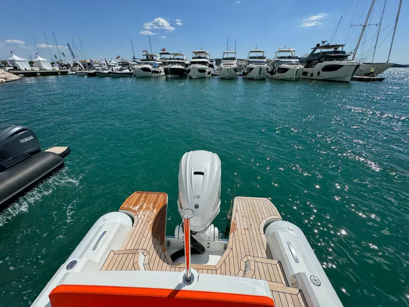 Slide: The Image of SuperRib Open 27 (2025) boat docked in a marina with other yachts. - 21