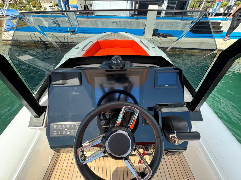 Slide: The Image of Cockpit view of 2025 SuperRib Open 27 boat with modern steering and controls. - 24