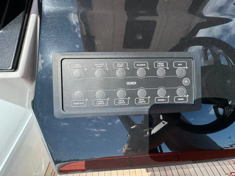 Slide: The Image of Control panel of a 2025 SuperRib Open 27 boat with various switches. - 25