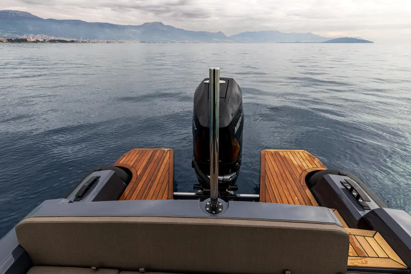 Slide: The Image of 2026 SuperRib Open 27 boat on calm water, featuring sleek design and wooden deck. - 3