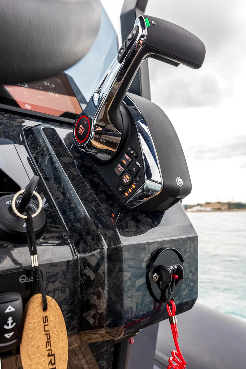 Slide: The Image of Close-up of 2026 SuperRib Open 27 boat controls with throttle and key. - 7