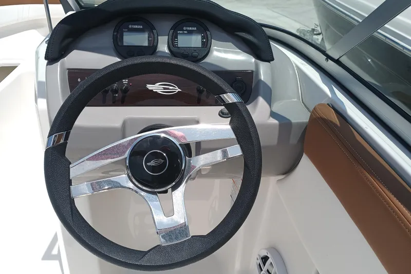 Slide: The Image of 2024 Chaparral 19 SSi OB boat dashboard with steering wheel and gauges. - 13