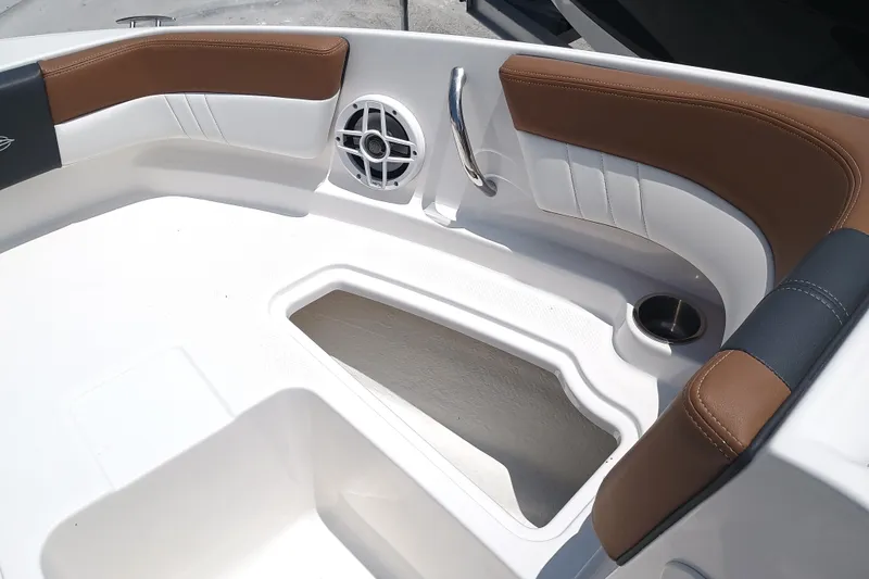 Slide: The Image of 2024 Chaparral 19 SSi OB boat interior with brown and white seating, speaker, and cup holder. - 18