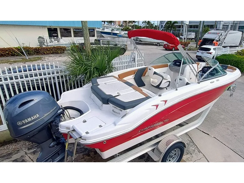 Slide: The Image of 2024 Chaparral 19 SSi OB boat with Yamaha outboard, red and white design, docked outdoors. - 4