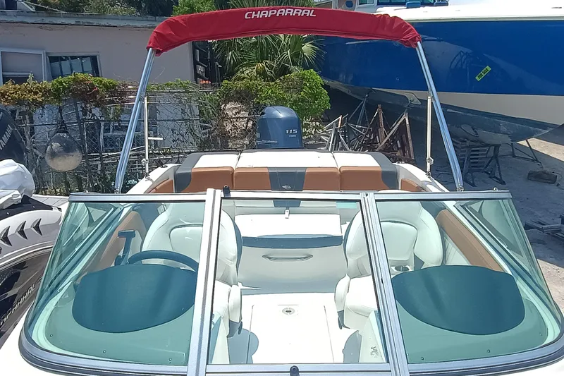 Slide: The Image of 2024 Chaparral 19 SSi OB boat with red canopy and sleek interior design. - 5