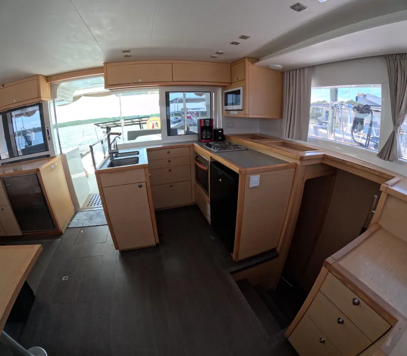 Slide: The Image of Interior of 2014 Lagoon 450 yacht kitchen with modern appliances and wooden cabinetry. - 10
