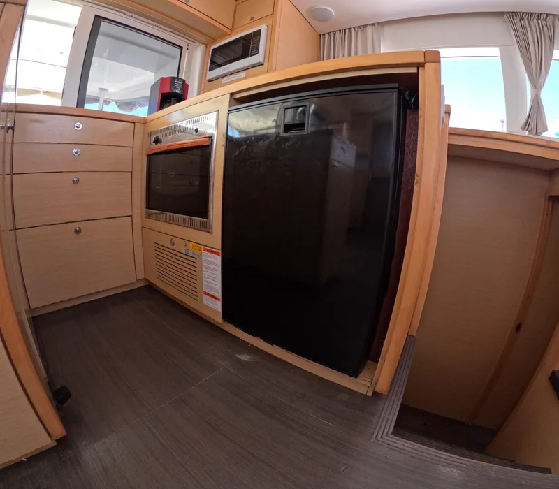 Slide: The Image of Modern kitchen interior of 2014 Lagoon 450 yacht with wood cabinetry and appliances. - 12