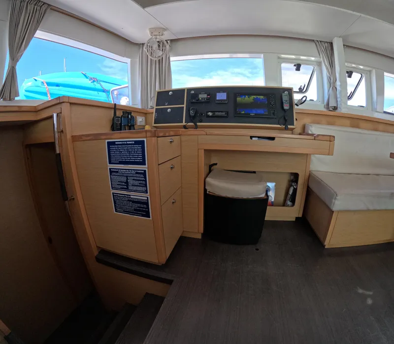 Slide: The Image of Interior of a 2014 Lagoon 450 catamaran with navigation equipment and seating area. - 15