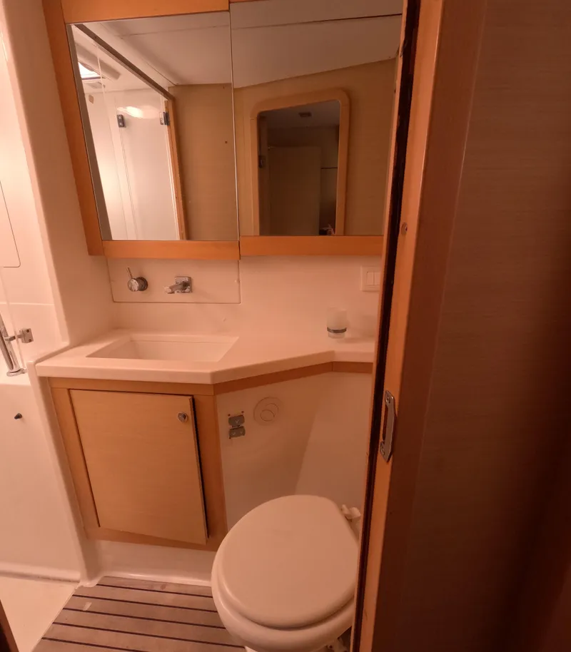 Slide: The Image of 2014 Lagoon 450 yacht bathroom with wooden cabinetry, mirror, and compact design. - 31