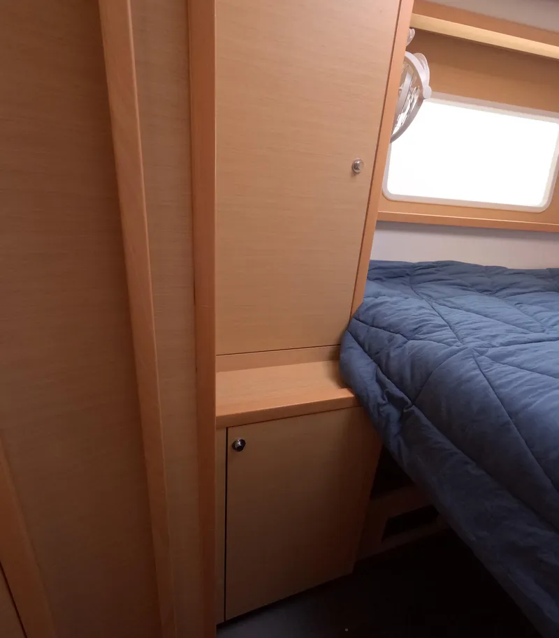 Slide: The Image of 2014 Lagoon 450 cabin interior with bed and wooden cabinetry. - 35
