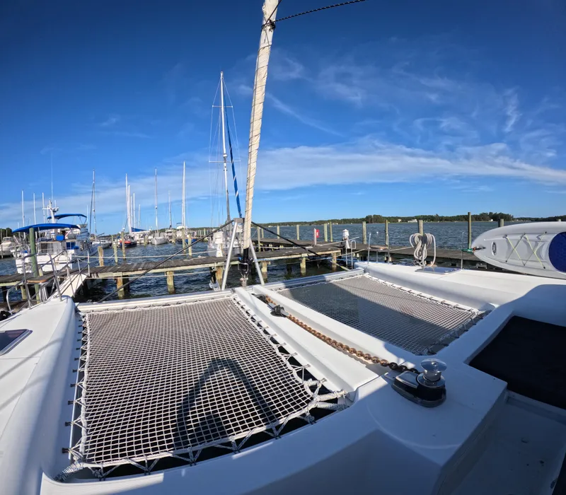 Slide: The Image of 2014 Lagoon 450 catamaran docked at a marina under clear blue skies. - 4