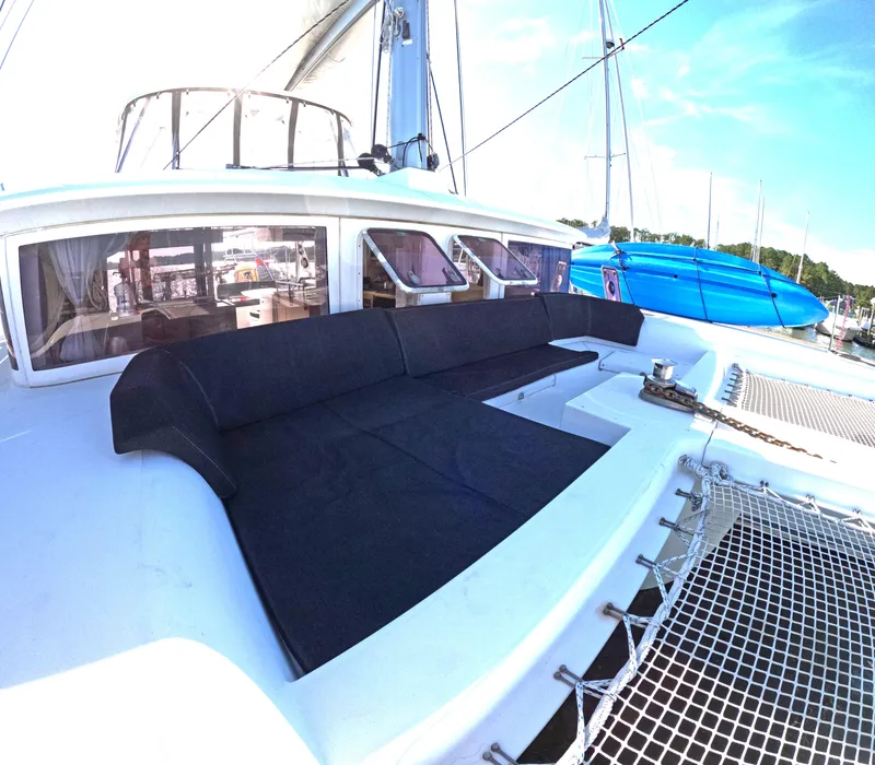 Slide: The Image of 2014 Lagoon 450 catamaran with spacious deck and seating area, docked at marina. - 5