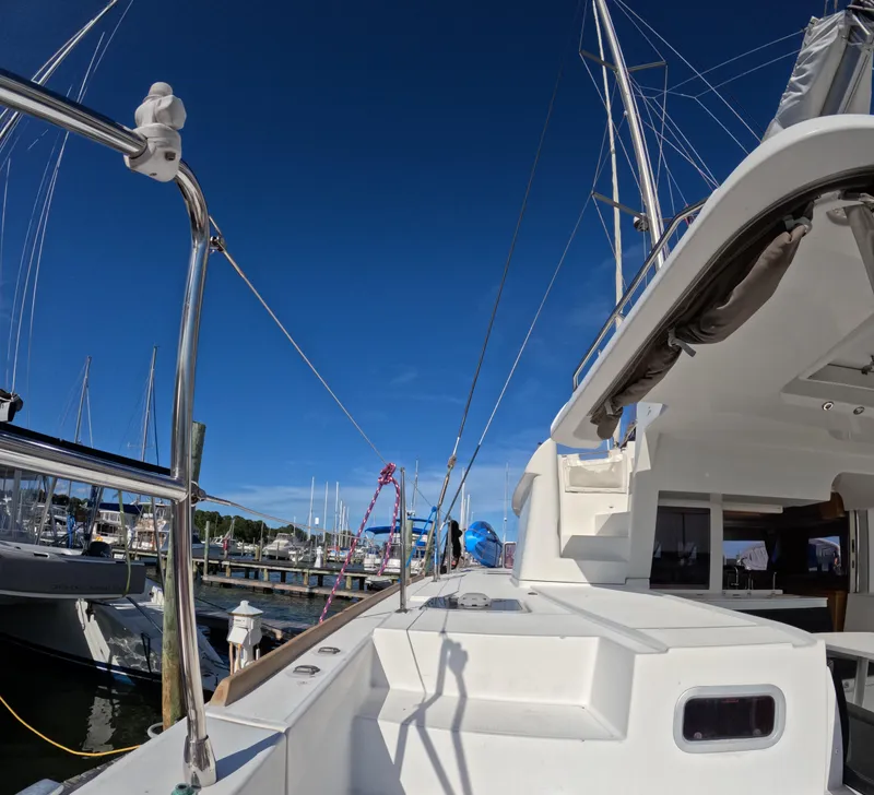 Slide: The Image of 2014 Lagoon 450 catamaran docked at marina under clear blue sky. - 7