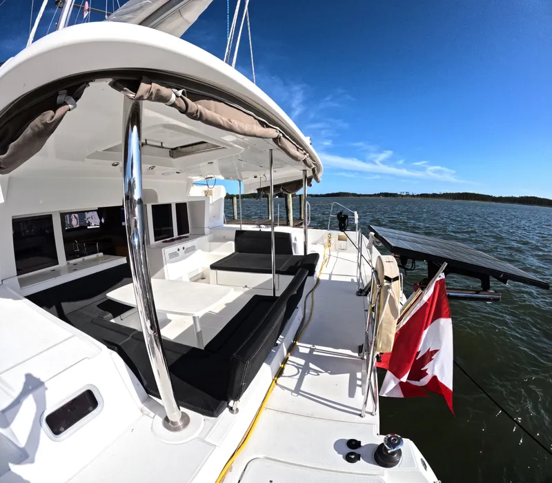 Slide: The Image of Lagoon 450 catamaran, 2014 model, docked with Canadian flag, sunny day, spacious deck. - 9
