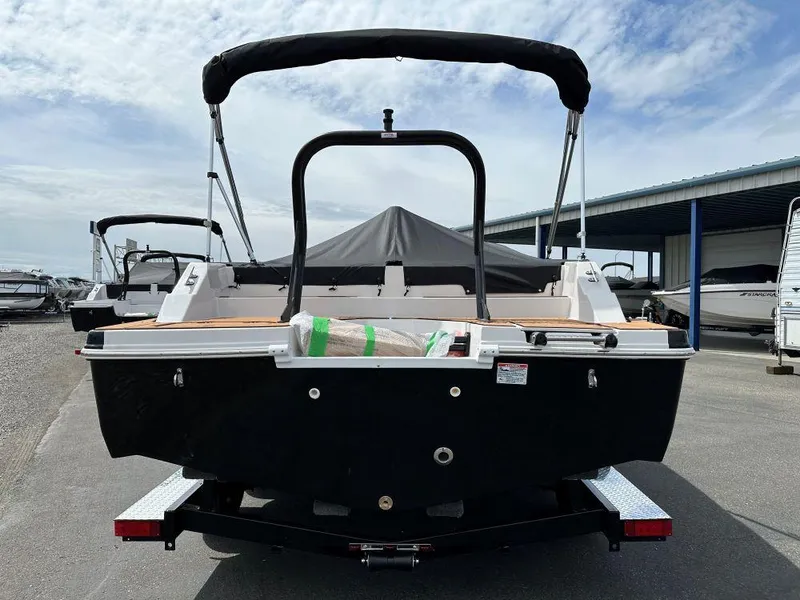 Slide: The Image of 2024 Starcraft SVX 211 OB boat, rear view, black hull, docked at marina. - 3