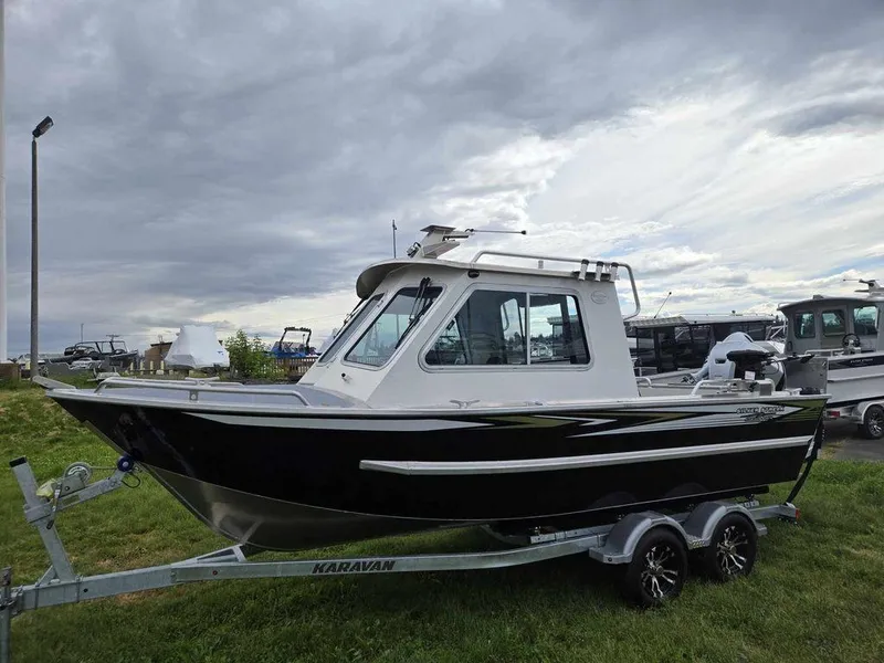 Slide: The Image of 2024 Silver Streak RENFREW boat on a Karavan trailer, parked on grass under a cloudy sky. - 0