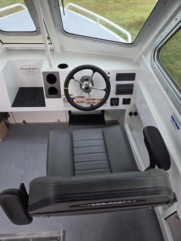 Slide: The Image of 2024 Silver Streak RENFREW boat cockpit with steering wheel and captain's chair. - 1