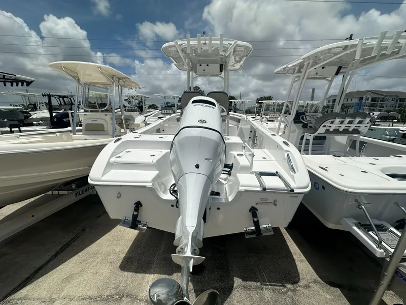 Slide: The Image of 2024 Sea Pro 222 Center Console boat displayed at a marina under a partly cloudy sky. - 3