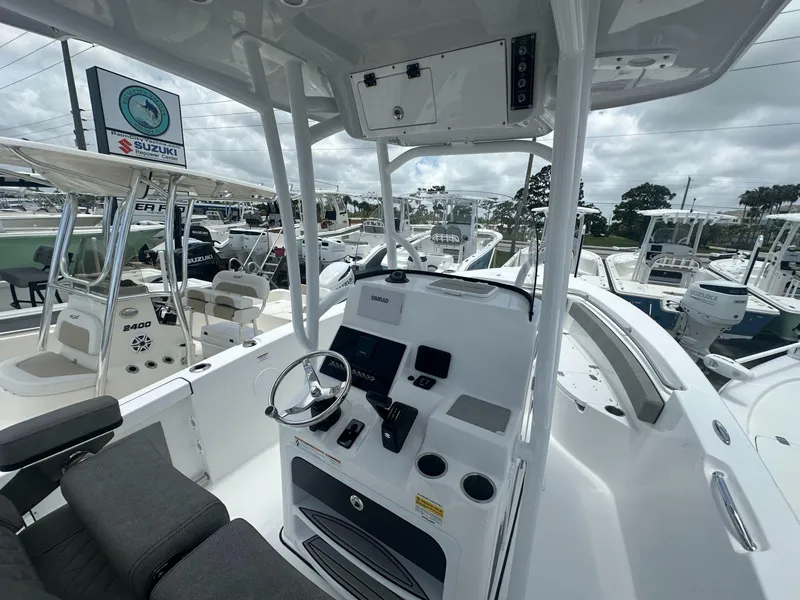 Slide: The Image of 2024 Sea Pro 222 Center Console boat interior with helm and seating, displayed at a dealership. - 4
