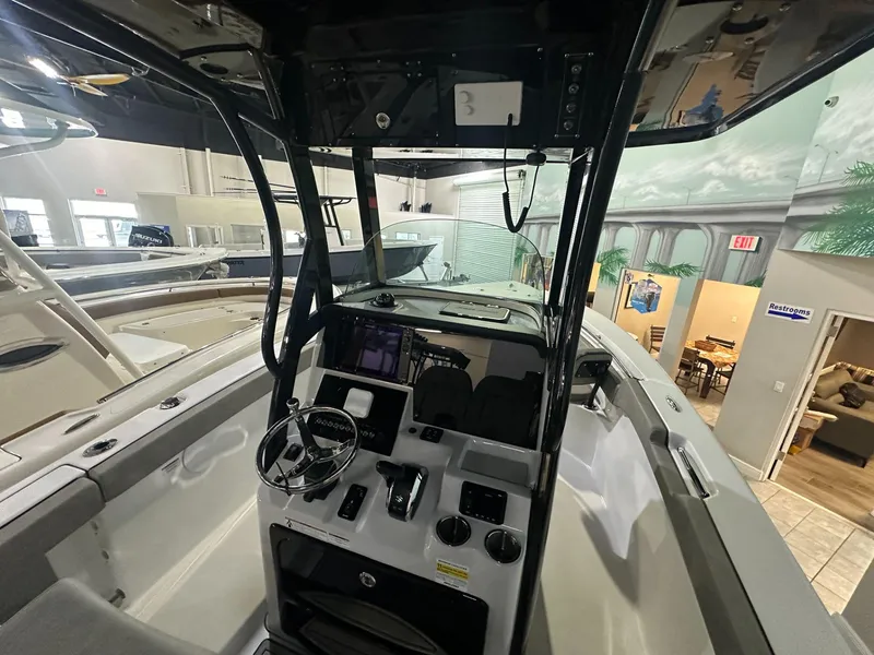 Slide: The Image of 2024 Sea Pro 242 Center Console boat interior with steering wheel and control panel. - 4