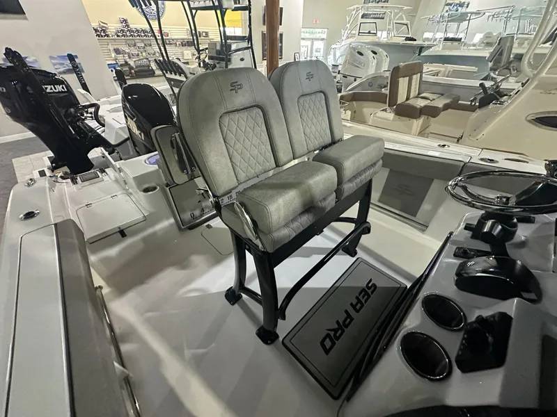 Slide: The Image of 2024 Sea Pro 242 Center Console boat interior with dual seats and Suzuki outboard motors. - 8