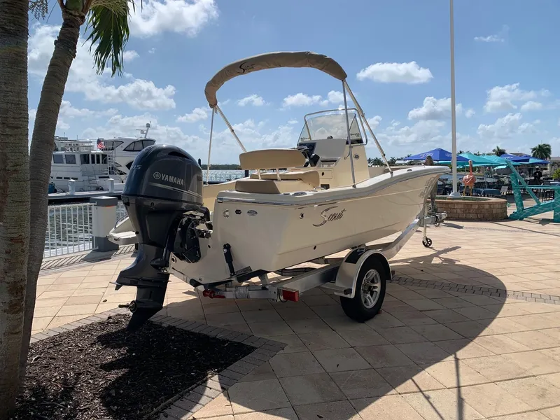 Slide: The Image of 2024 Scout 195 Sportfish boat on trailer at marina. - 2