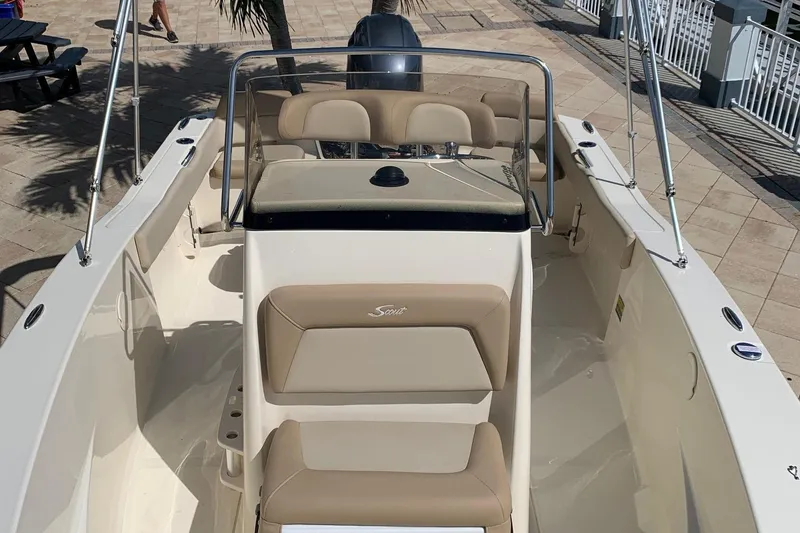 Slide: The Image of 2024 Scout 195 Sportfish boat interior with beige seating and steering console. - 4