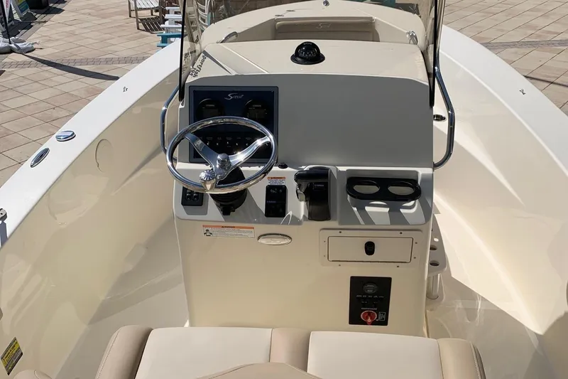 Slide: The Image of 2024 Scout 195 Sportfish boat console with steering wheel and controls. - 5