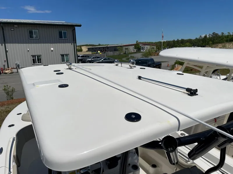 Slide: The Image of 2022 Key West 263 FS boat roof with rod holders, parked near industrial building. - 16