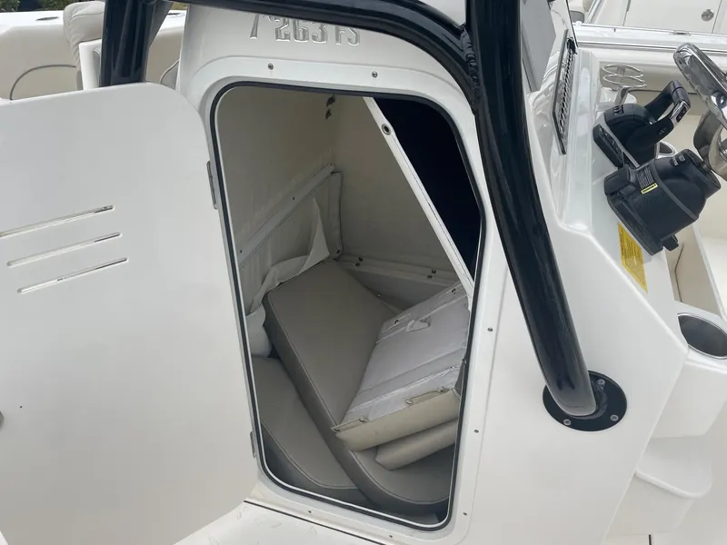 Slide: The Image of 2022 Key West 263 FS boat interior storage compartment with open door. - 23
