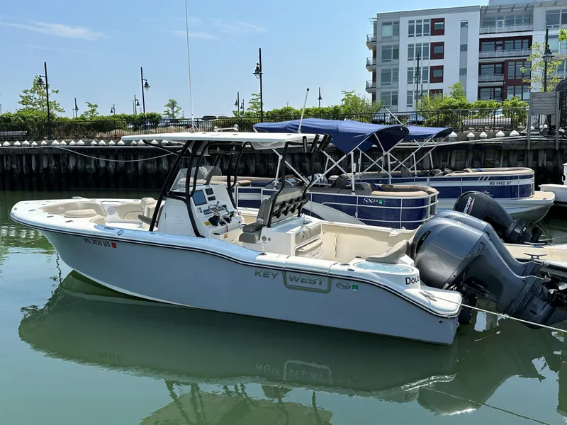 Slide: The Image of 2022 Key West 263 FS boat docked in a marina with other boats. - 24
