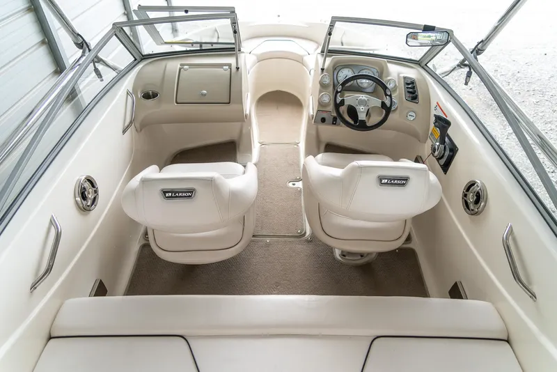Slide: The Image of 2010 Larson LX 1850 boat interior with dual captain seats and steering console. - 10