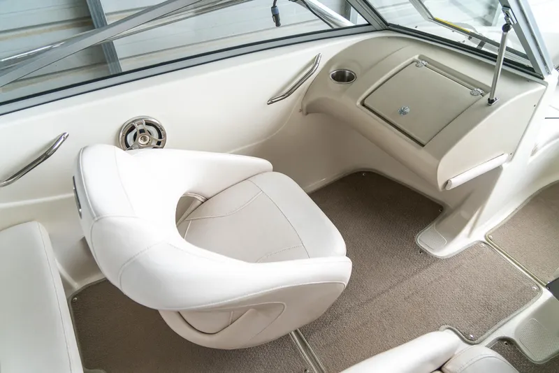 Slide: The Image of Interior of a 2010 Larson LX 1850 boat with white seating and beige carpet. - 12