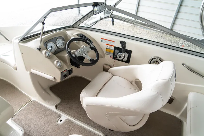 Slide: The Image of 2010 Larson LX 1850 boat interior with steering wheel and captain's chair. - 13